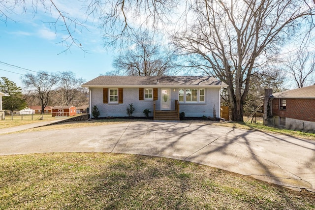 view of front of home with a front yard, brick siding, and fence