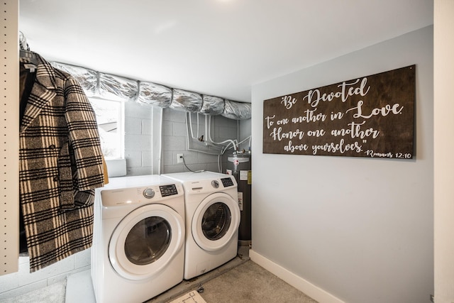 clothes washing area featuring water heater, washing machine and clothes dryer, concrete block wall, and baseboards