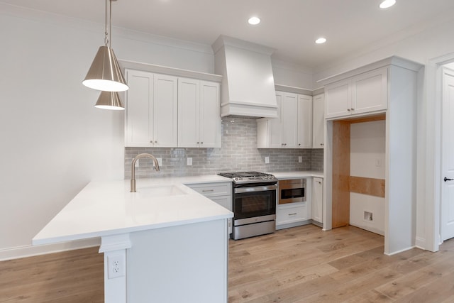 kitchen with premium range hood, white cabinets, hanging light fixtures, appliances with stainless steel finishes, and light countertops