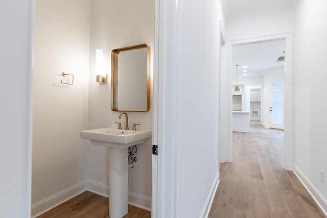 bathroom with baseboards and wood finished floors