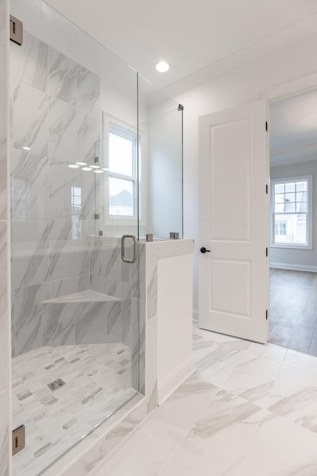 bathroom with a healthy amount of sunlight, marble finish floor, a shower stall, and recessed lighting