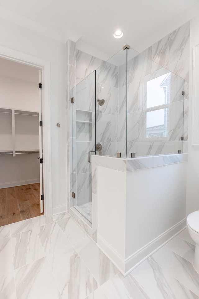 bathroom with a marble finish shower, baseboards, marble finish floor, a spacious closet, and recessed lighting