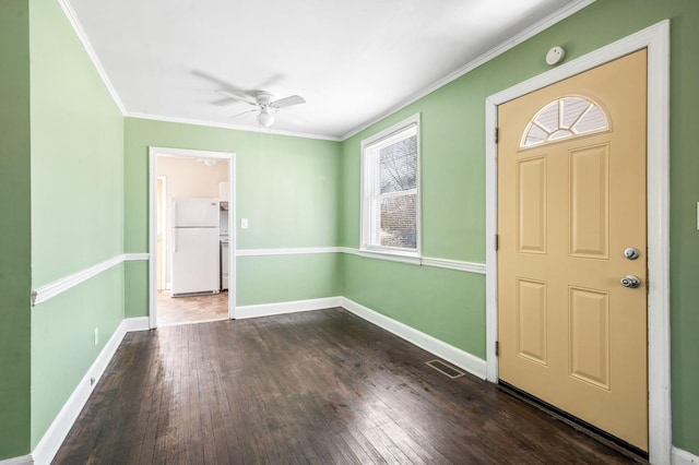 foyer entrance with ceiling fan, dark wood-type flooring, visible vents, baseboards, and ornamental molding