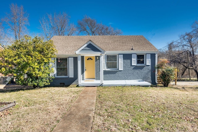 view of front facade featuring a shingled roof, crawl space, brick siding, and a front lawn