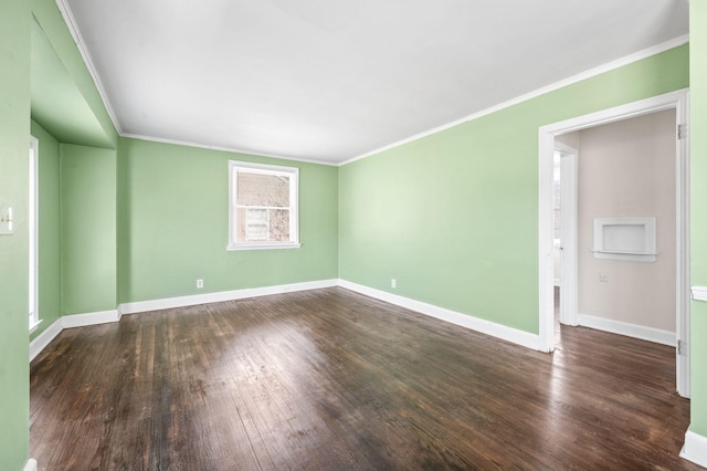 empty room with baseboards, dark wood finished floors, and crown molding