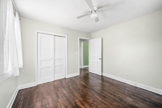 unfurnished bedroom featuring a closet, dark wood-style flooring, baseboards, and a ceiling fan