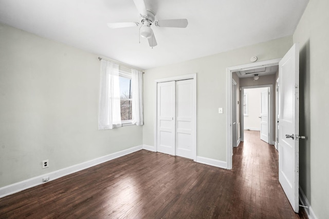 unfurnished bedroom with ceiling fan, a closet, dark wood finished floors, and baseboards