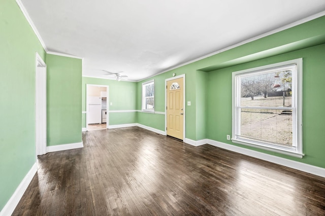 unfurnished living room featuring ornamental molding, dark wood-style flooring, baseboards, and a ceiling fan