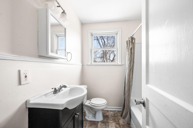 bathroom with toilet, shower / tub combo, baseboards, and vanity