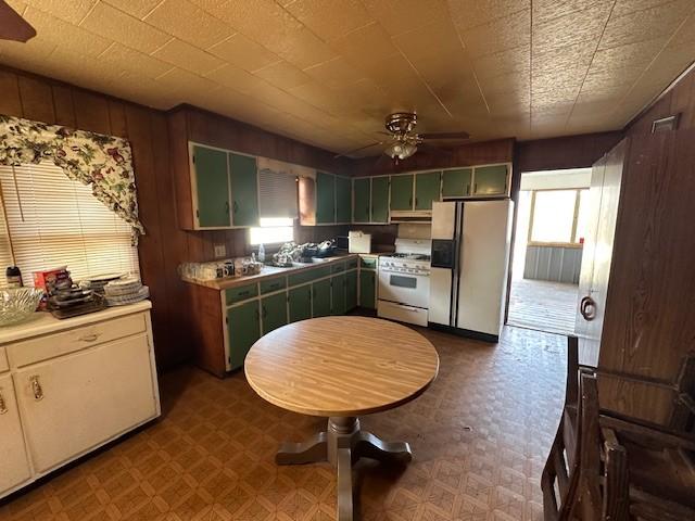 kitchen with light countertops, tile patterned floors, refrigerator with ice dispenser, and white range with gas cooktop