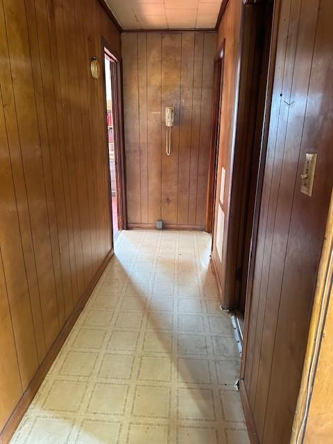 hallway with wooden walls and light floors