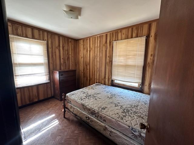 bedroom featuring wooden walls