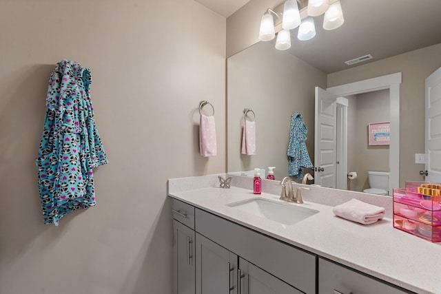 bathroom featuring visible vents, vanity, and toilet