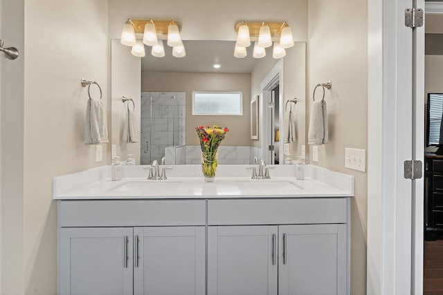 full bath with double vanity, a sink, and a shower stall