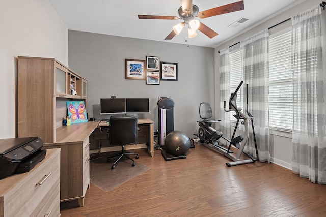 office space with a ceiling fan, visible vents, light wood-style flooring, and baseboards