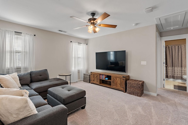 living area with attic access, light colored carpet, a wealth of natural light, and visible vents