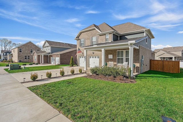 view of front of property with brick siding, fence, driveway, a residential view, and a front yard