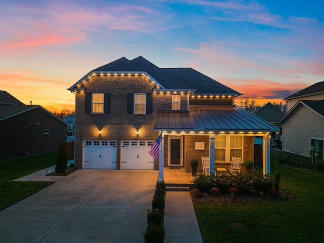 view of front of house featuring brick siding, a porch, concrete driveway, an attached garage, and a standing seam roof