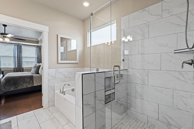 bathroom featuring a stall shower, ceiling fan, ensuite bathroom, marble finish floor, and tile walls