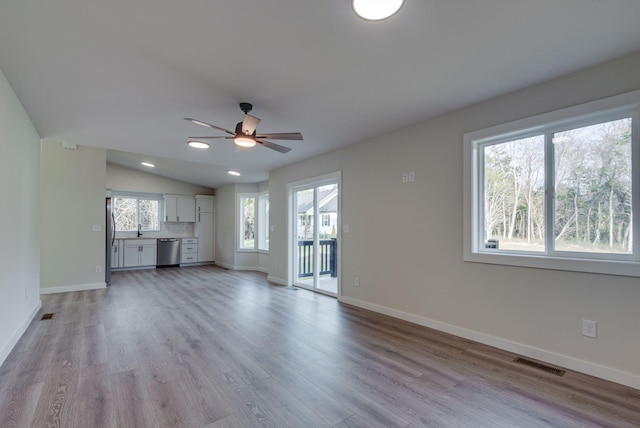 unfurnished living room featuring lofted ceiling, recessed lighting, visible vents, light wood-style flooring, and baseboards