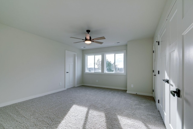 unfurnished room featuring carpet, baseboards, and a ceiling fan