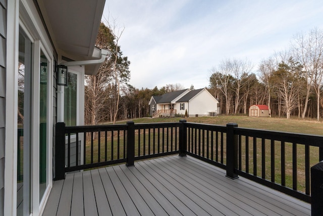 deck featuring a yard, a storage unit, and an outdoor structure