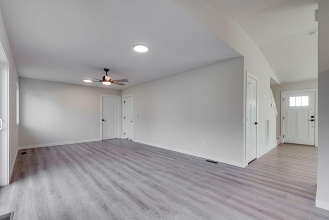 spare room with baseboards, light wood-type flooring, visible vents, and a ceiling fan