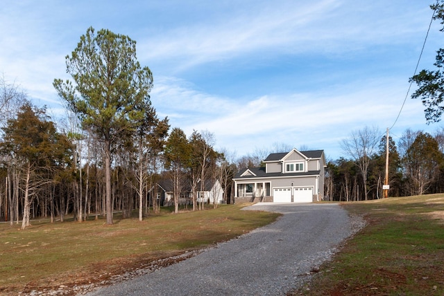 view of front facade featuring a front yard, gravel driveway, and an attached garage