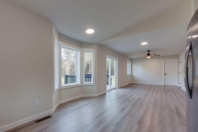 interior space with visible vents, ceiling fan, light wood-style flooring, and baseboards