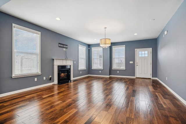 unfurnished living room with a fireplace with flush hearth, recessed lighting, dark wood-style flooring, and baseboards