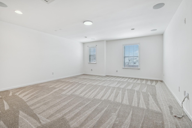 unfurnished room with baseboards and light colored carpet