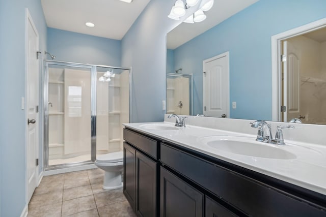 bathroom with tile patterned flooring, a sink, a shower stall, and double vanity