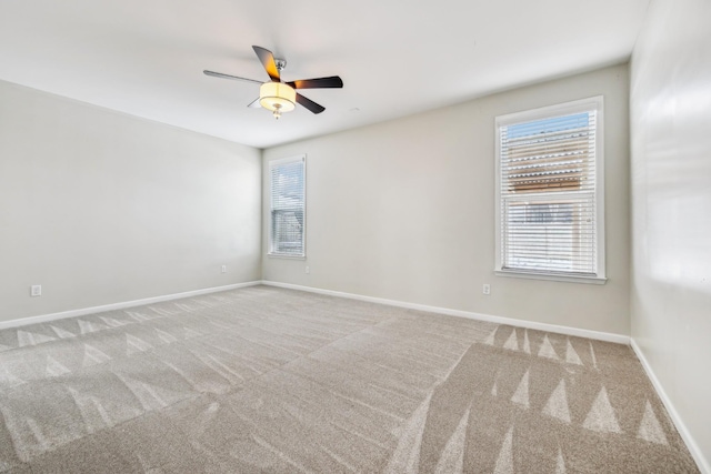 spare room with light carpet, ceiling fan, and baseboards