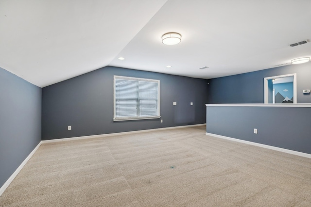 additional living space with lofted ceiling, recessed lighting, light colored carpet, visible vents, and baseboards