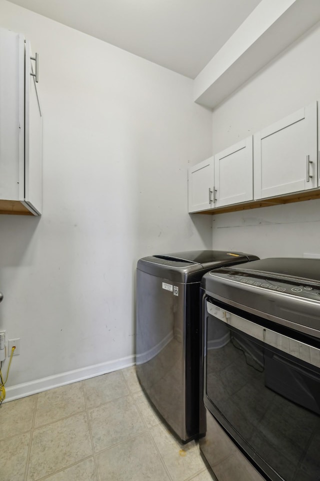 laundry area featuring cabinet space, independent washer and dryer, baseboards, and light tile patterned floors