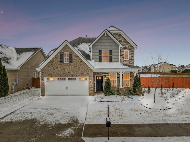 view of front of house with a garage, driveway, brick siding, and fence