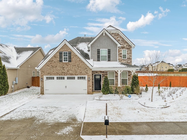 view of front facade featuring brick siding, fence, driveway, and an attached garage