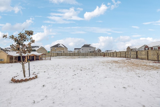 snowy yard with fence and a residential view