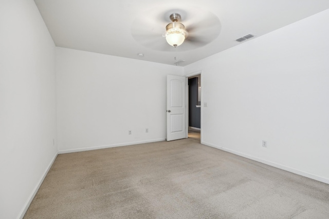 empty room with light carpet, ceiling fan, visible vents, and baseboards