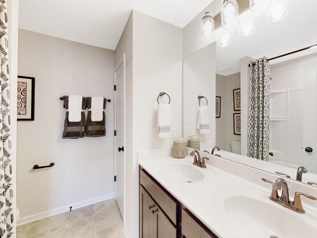 bathroom with double vanity, a sink, toilet, and a shower with curtain