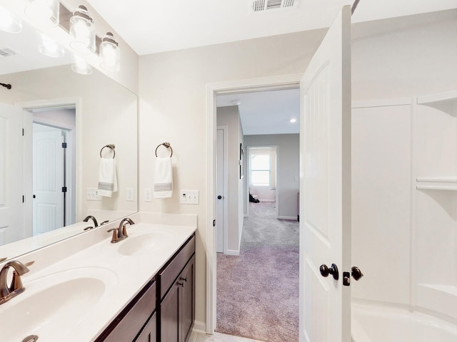 bathroom featuring visible vents, a sink, baseboards, and double vanity