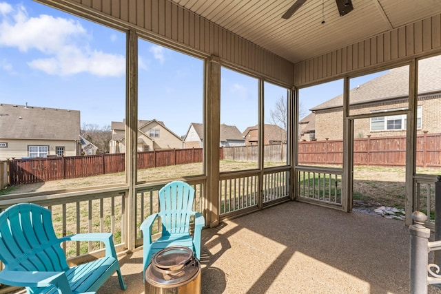 sunroom with plenty of natural light, a residential view, and ceiling fan