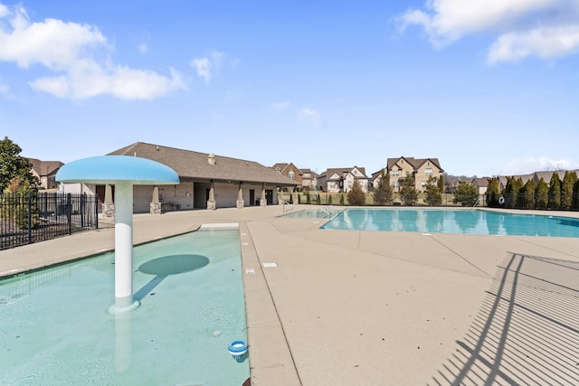 pool with a residential view, a patio area, and fence