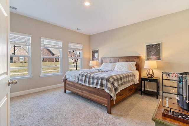 bedroom with light colored carpet, visible vents, and baseboards