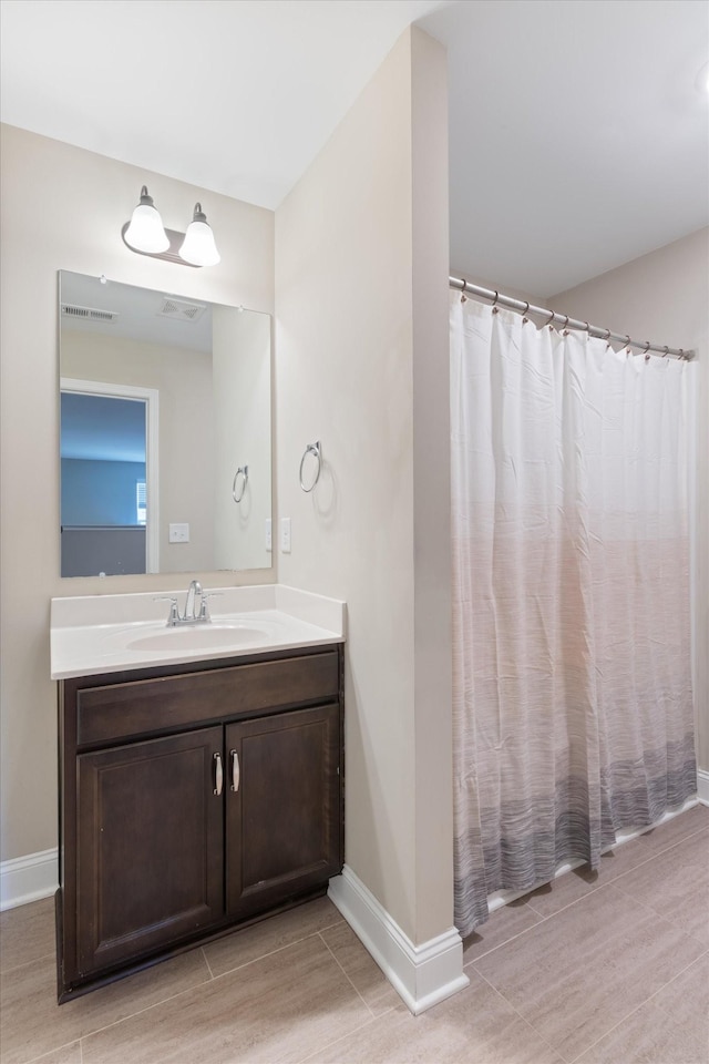 full bathroom with visible vents, vanity, and baseboards