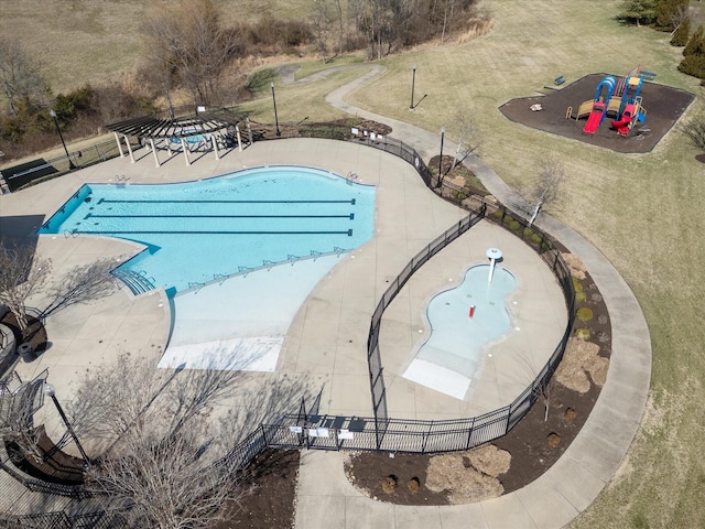 pool with playground community, a yard, a patio, and fence