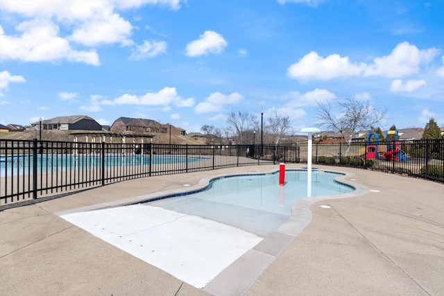 community pool with a residential view, fence, and a patio