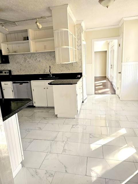 kitchen featuring dark countertops, marble finish floor, white cabinetry, open shelves, and a sink