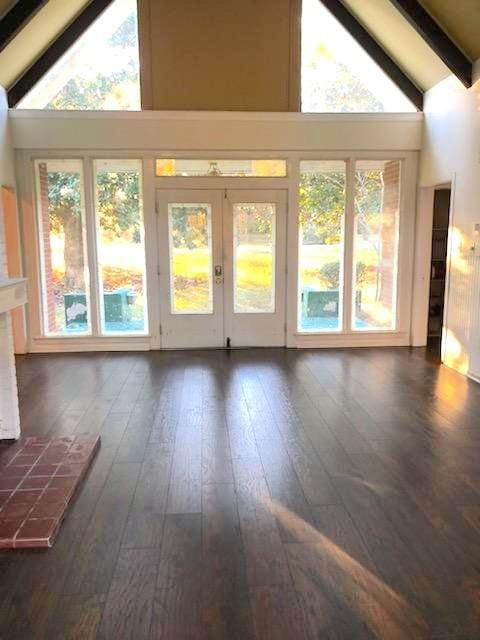 interior space with a healthy amount of sunlight, high vaulted ceiling, dark wood-type flooring, and beam ceiling