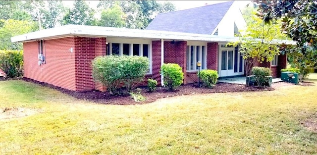 exterior space with brick siding and a front lawn